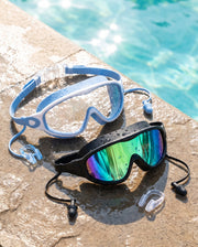 Wavlee kids swim goggles in blue and black resting on a wet pool edge