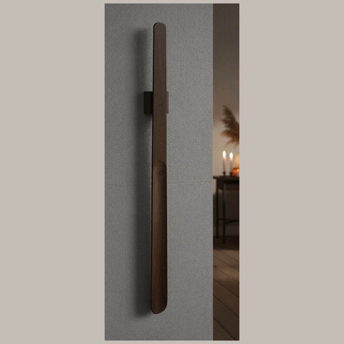 A dark-wood Norlund magnetic shoehorn mounted on a hallway wall